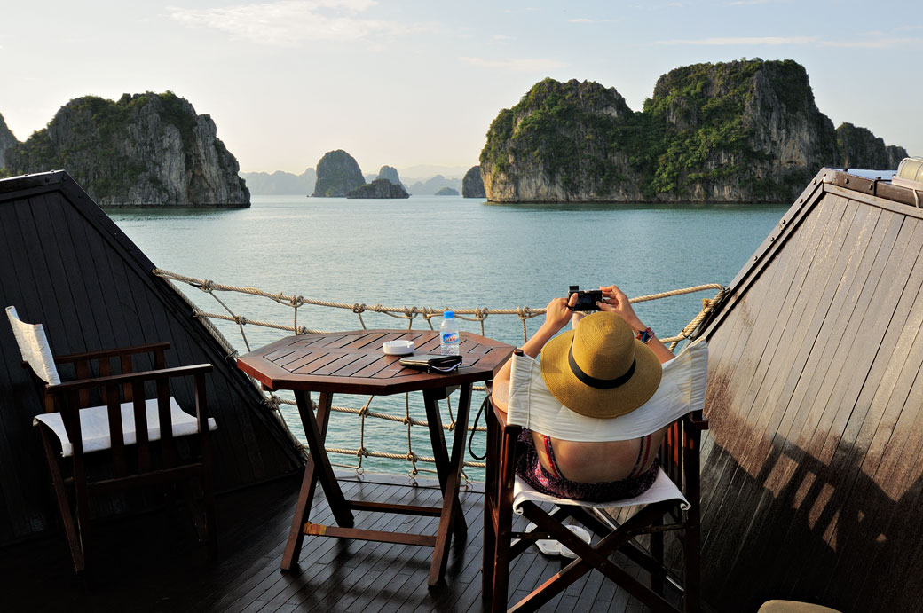 Femme qui se relax sur le pont d'un bateau dans la baie d'Halong