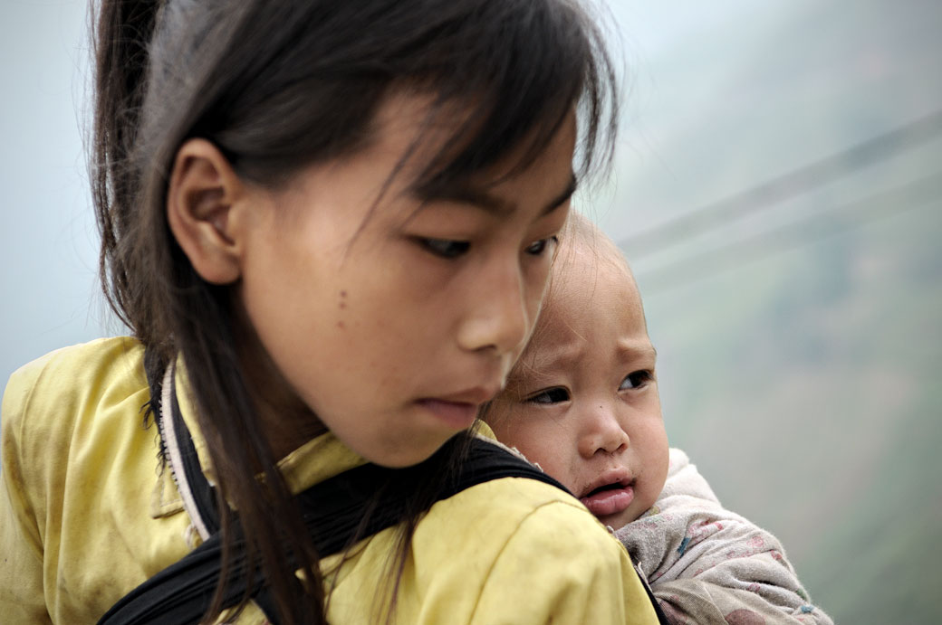 Bébé sur le dos de sa soeur, Vietnam