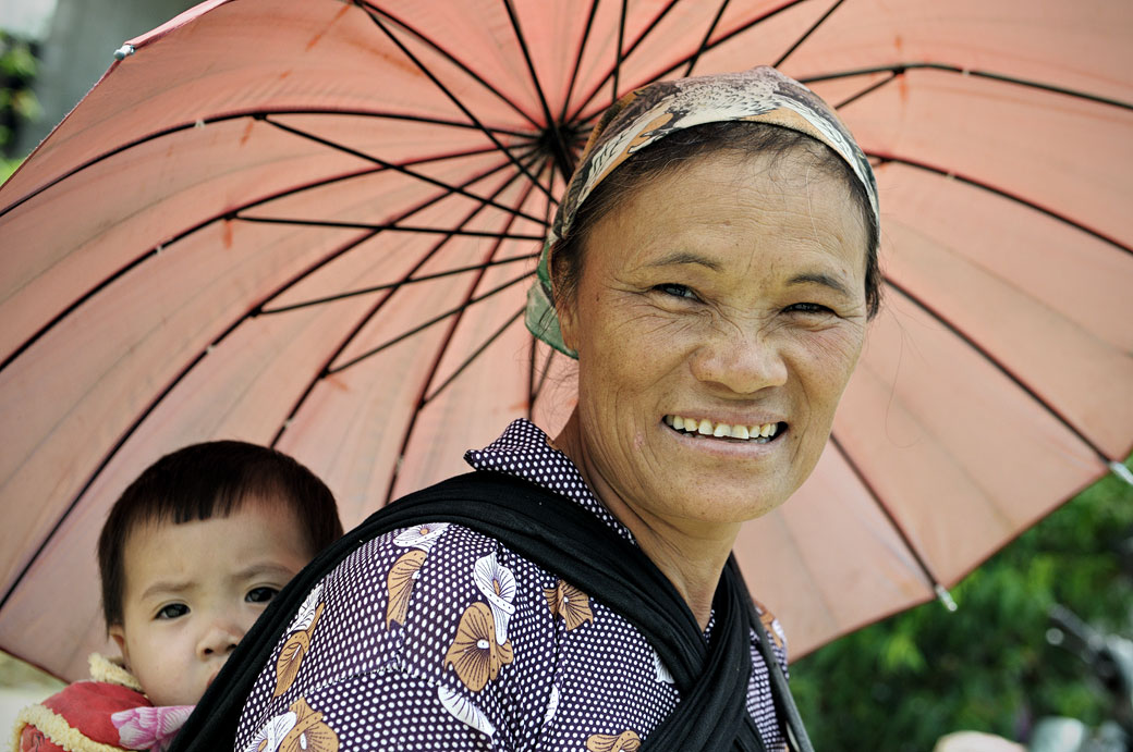 Femme et bébé sous une ombrelle à Quyet Tien, Vietnam